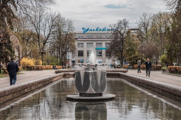 a fountain in a park with people walking around